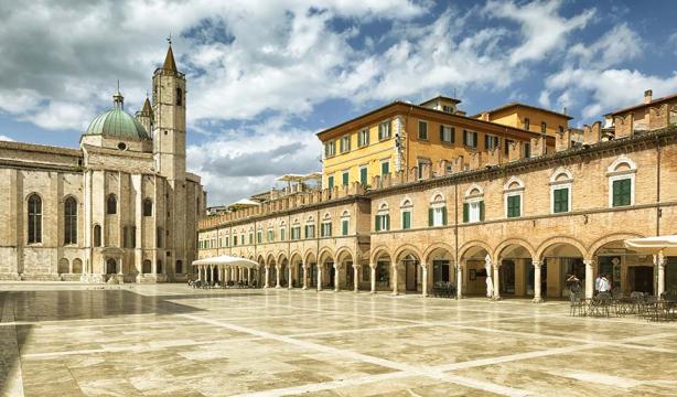 Historic square with majestic architecture, blue sky, and serene atmosphere.