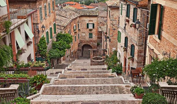Brick staircase between ancient houses, lush greenery, and a peaceful atmosphere.